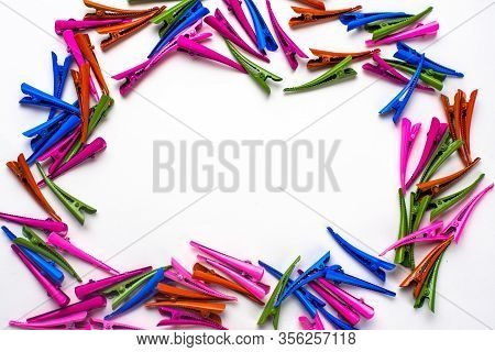 Many Multi- Colored Hair Clips In The Form Of A Frame , In The Middle Of The White Background For Th