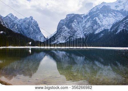The Snowy Dolomites Are Reflected In The Calm Waters Of Lake Dobbiaco In Winter, Trentino Alto Adige