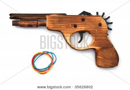 木製のおもちゃの銃と白い背景の上の弾性バンド