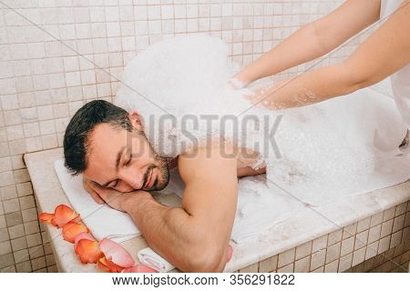 Luxury Relaxation Oriental Man In A Turkish Bath. Hammam Worker Washes Mens Skin In Hammam