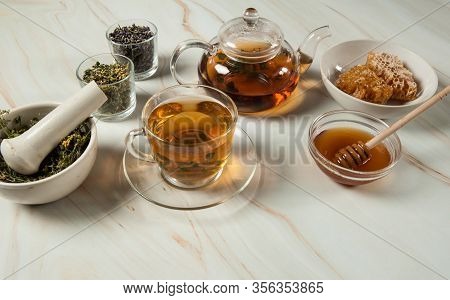 Healthy And Delicious Herbal Tea With Honey. A Teapot, Tea In A Glass Cup, Sweet Golden Honey And A 