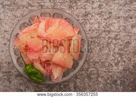 Pomelo (robab Tenga) Citrus Fruit Inner Parts With Ghost Chili Pepper (bhut Jolokia) In A Glass Bowl