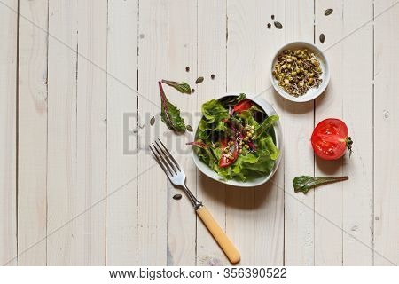 Mixed Salad With Munga Bean Sprouts And Pumpkin Seeds, Top View On Light Boards With Space