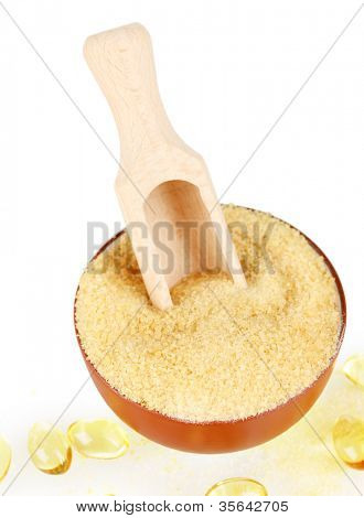 Gelatin in a bowl and wooden spoon on white background close-up
