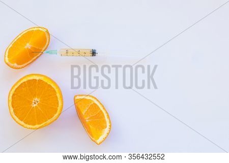 High Dose Vitamin C, Ampule For Injection. Syringe In Fresh Juicy Orange Fruit Slides. Concept Of Vi
