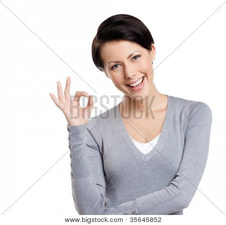 Young lighthearted girl shows Okay gesture, isolated on white