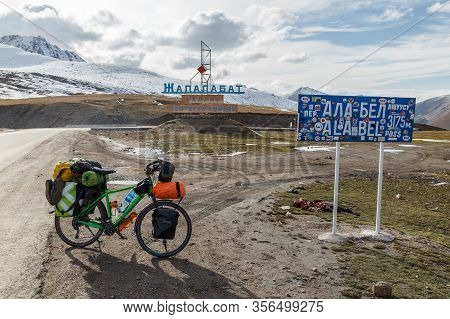 Chuy Province, Kyrgyzstan - October 07, 2019: A Tourist Bike With Bags Is Standing Near The Sign Of 