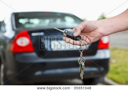 Man Hand te drukken op de afstandsbediening auto-alarmsystemen