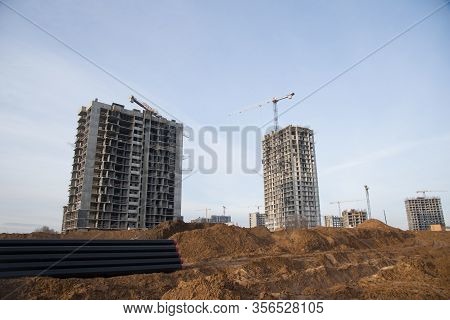Tower Cranes Constructing A New Residential Build. Formwork Of Building At Construction Site. Laying