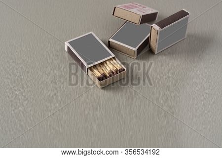 Open Box Of Matches And Closed Boxes Of Matches On A Grey Background