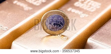 One Real Coin And Gold Bars. Concept Of Appreciation Of The Brazilian Currency In The Stock Market.