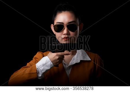 Portrait Beautiful Asea Woman Wearing A Yellow Suit One Hand Holding Pistol Gun At The Black Backgro