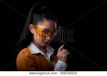 Portrait Beautiful Asea Woman Wearing A Yellow Suit One Hand Holding Pistol Gun At The Black Backgro