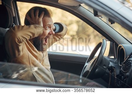 Crazy Angry Man Annoyed While Driving A Car. Mad Agrressive Driver Screaming Irritated With Traffic