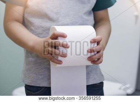 Cropped Shot Of Kid Hands Holding Toilet Roll, Little Boy Suffers From Diarrhoea Holding Toilet Pape