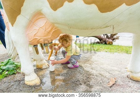 Cute Blonde Girl Learning How To Milk A Cow On Milking Simulator.