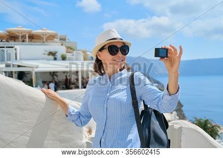 Woman Travel Vloger Traveling In Greek Village Of Oia On Santorini Island, Filming Aktion Camera Vid