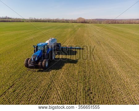 Tractor Applying Liquid Mineral Fertilizers To The Soil On Winter Wheat