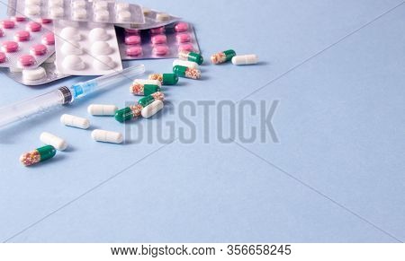 Coronavirus Phrase Text On A Blue Background With Medicines And A Syringe. The Concept Of The New 20