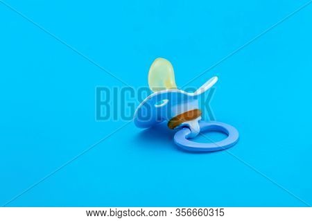 A Pacifier With A Bite For Babies Made Of Soft Silicone, Soother Isolated On Blue Background With Co