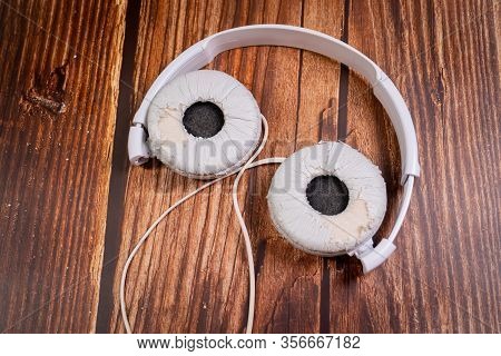 Need A Replacement Embouchures On Old White Earbud. Repair Accessories.wooden Background