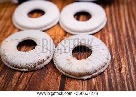 Need A Replacement Embouchures On Old White Earbud. Repair Accessories.wooden Background