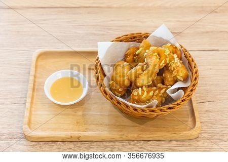 Padnoongo With White Sesame And Rice In A Container On A Wooden Tray And Condensed Milk On The Woode