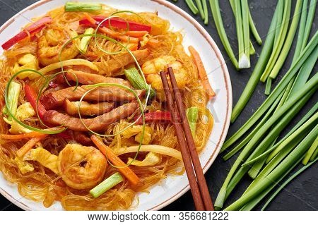 Singapore Mei Fun In White Plate On Dark Slate Background. Singapore Noodles Is Chinese Cuisine Dish