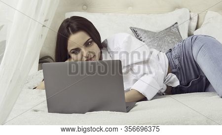 Girl Laying In Bed And Using Laptop. Working From Home