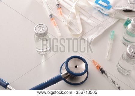 Vials And Syringes On White Table With Medical Equipmen. Top View. Horizontal Composition.
