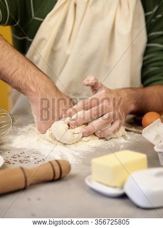 Male Hands Kneading Dough On Wooden Table. Hands Kneading Dough Isolated On Yellow Orange Background