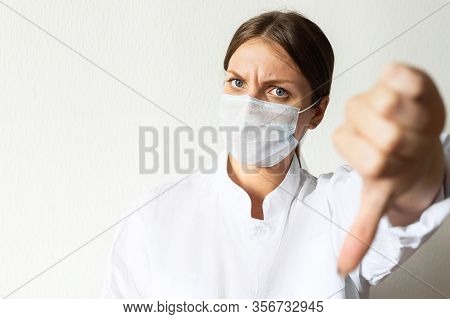 Nurse Isolated On White With Thumbs Down Putting On A Mask To Protect From Airborne Respiratory Dise
