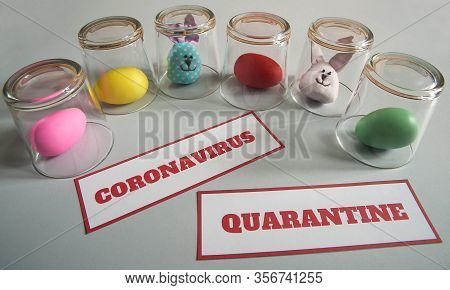The Concept Of Quarantine At Easter Time. Easter Bunny And Painted Eggs In Glass Cups, A Message Abo
