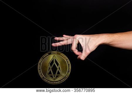 The Symbol Of The New Popular Cryptocurrency Eosio With The Image Of Hands On Dark Background