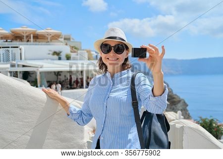 Woman Travel Vloger Traveling In Greek Village Of Oia On Santorini Island, Filming Aktion Camera Vid
