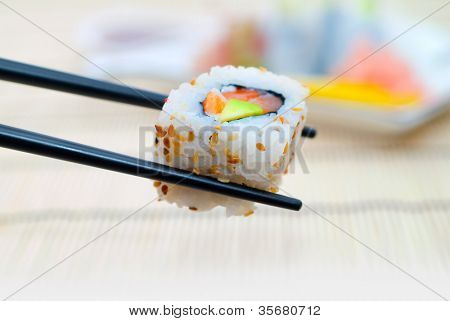 Sushi con le bacchette, con un fondo schiena