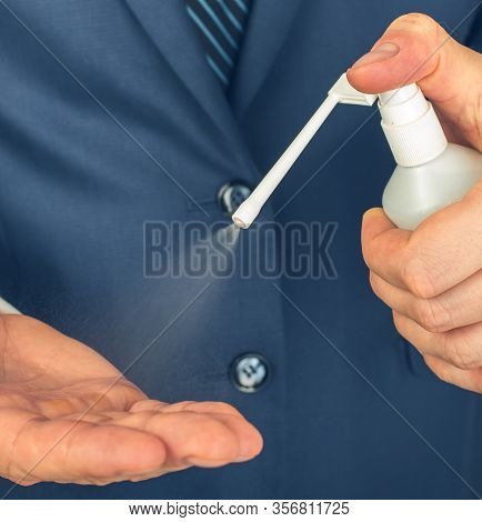 A Man Sprays Alcohol Antiseptics From A Spray Bottle On His Hand