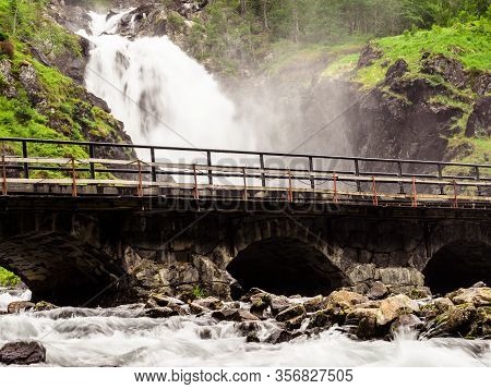 Norwegian Landscape. Waterfall Latefoss Latefossen With Stone Arched Bridge Road, Odda Hordaland Nor