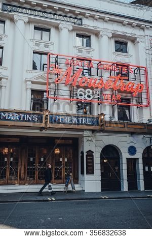 London, Uk - March 06, 2020: Man Walking Past Mousetrap Neon Sign On The Facade Of St Martins Theatr