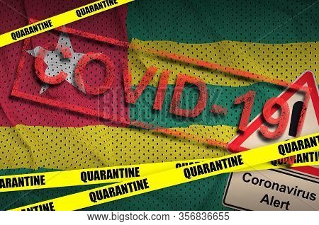 Togo Flag And Covid-19 Quarantine Yellow Tape With Red Stamp. Coronavirus Or 2019-ncov Virus