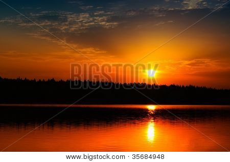 Hermoso amanecer / puesta de sol sobre el lago tranquilo