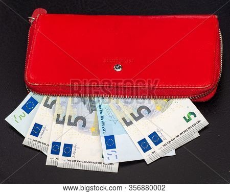 Close Up Of Bundles Of Euro Banknotes And Opening A Red Wallet On A Dark Background. Selective Focus