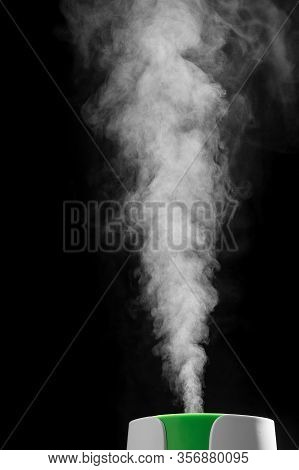 Ultrasonic Humidifier Releases Water Vapor From The Hole. On Black Background. The Process Of Operat