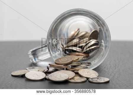 Trifle Russian Coins Pouring From A Glass Jar On A Dark Background, The Concept Of Coins Of Low Deno