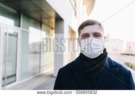 Caucasian Young Man Near His Office Wearing Surgical Face Mask To Protect From Coronavirus Covid-19