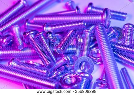 Metal Bolts And Nuts  In A Row Background. Chromed Screw Bolts And Nuts In Blue And Pink Tones. Stee