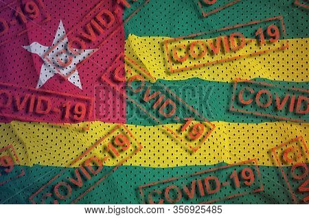 Togo Flag And Many Red Covid-19 Stamps. Coronavirus Or 2019-ncov Virus Concept