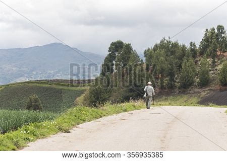 Aquitania, Boyaca / Colombia; April 8, 2018: Man Walking On A Country Road, In The Middle Of A Green