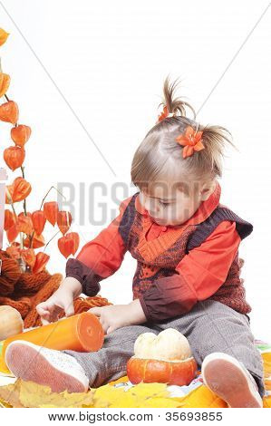 kleines MÃ¤dchen in einer orange Weste spielt mit groÃŸen KÃ¼rbisse