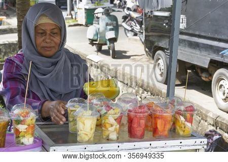 Banda Aceh, Indonesia - January 5, 2020. Saleswoman In The Muslim Dress Sells On The Street Counter 